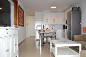 a kitchen with white cabinets and a table and chairs at Looking the VIEWS - 214 in Costa Del Silencio