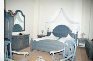 a bedroom with a blue bed and two chairs at Hotel Restaurant Bieberstuben in Menden