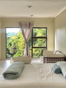 a bedroom with two beds and a large window at Bugera's Palace in Pretoria