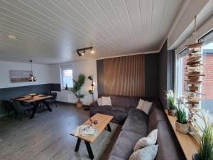 ein Wohnzimmer mit einer Couch und einem Tisch in der Unterkunft Ferienhaus Ohrenqualle in Dornum