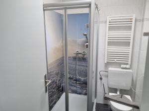 ein Bad mit einer Dusche und einem WC mit Aussicht in der Unterkunft Ferienhaus Ohrenqualle in Dornum + 23 Fotos