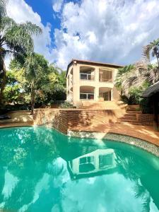 a swimming pool in front of a house at Bugera's Palace in Pretoria
