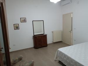 a bedroom with a mirror on a dresser and a bed at Casa Vacanze Salento in Matino