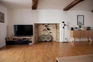 a living room with a flat screen tv and a wooden floor at Maison centre Hennebont in Hennebont