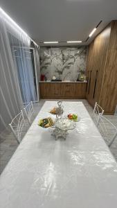 ein Esszimmer mit einem weißen Tisch und Stühlen in der Unterkunft Уютная квартира студия 72 кв in Oral