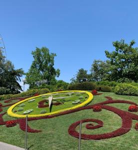 a garden with a clock in the grass at Studio moderne et chaleureux au coeur de Geneve - parfait pour courts sejours in Geneva