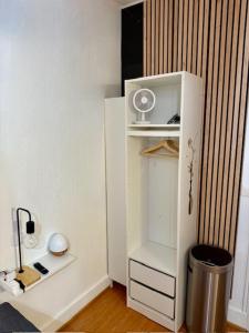 a room with a white refrigerator and a trash can at Studio moderne et chaleureux au coeur de Geneve - parfait pour courts sejours in Geneva