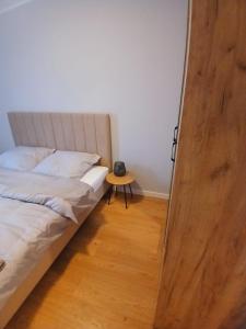 a bedroom with a bed and a small table at Słoneczny Apartament in Kłodzko +8 photos