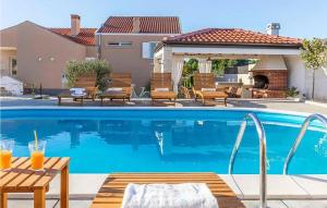a swimming pool with a table and chairs next to a house at Luxurious Home In Vrsi in Vrsi +35 photos