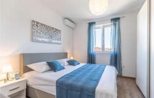 a bedroom with a large bed with blue sheets and a window at Luxurious Home In Vrsi in Vrsi