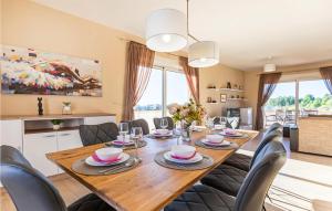 a dining room with a wooden table and chairs at Luxurious Home In Vrsi in Vrsi