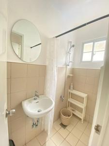 a white bathroom with a sink and a mirror at Lady Liberty Residence in Panglao