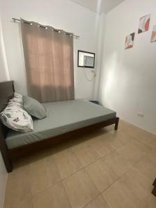 a bed in a room with a window at Lady Liberty Residence in Panglao +8 photos