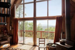 un soggiorno con ampia porta a vetri con vista di Cozy w 5 Private Acres Deck Grill & Dog Friendly a Slanesville