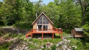 una piccola casa con un ampio ponte nel bosco di Cozy w 5 Private Acres Deck Grill & Dog Friendly a Slanesville