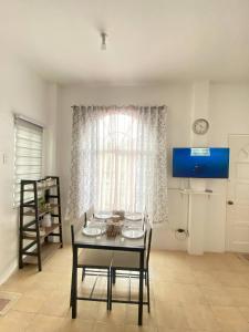 a dining room with a table and chairs and a window at Lady Liberty Residence in Panglao