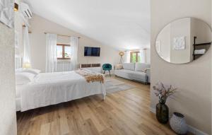 Un dormitorio blanco con una cama y un espejo. en 8 Bedroom Beautiful Home In Visnjan, en Višnjan