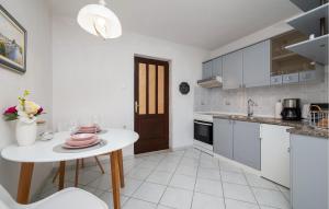 a white kitchen with a white table and a white counter top at 1 Bedroom Awesome Apartment In Rabac in Rabac