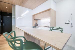 a kitchen with a wooden table and two green chairs at White apartment in Playa del Carmen