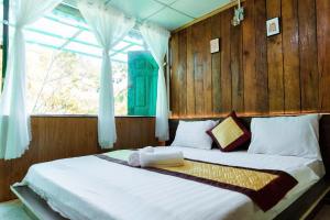a bedroom with a large bed with a window at Ở Đây Thôi - Homestay Đà Lạt in Manline