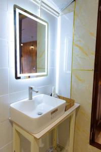 a bathroom with a white sink and a mirror at Ở Đây Thôi - Homestay Đà Lạt in Manline