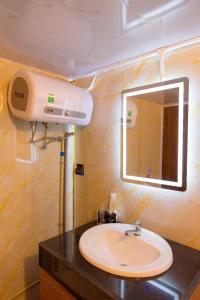 a bathroom with a sink and a mirror at Ở Đây Thôi - Homestay Đà Lạt in Manline