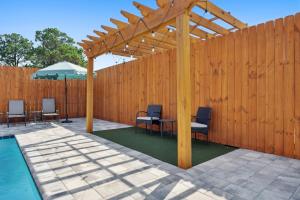 a wooden pergola with chairs and a table next to a pool at Grand Retreat II: 4BR, 5BA, sleeps 15 Private pool Your perfect escape! in Sunnyside
