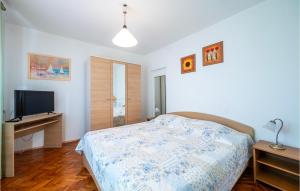 Un dormitorio con una cama y un escritorio con televisión. en Gorgeous Apartment In Rabac With Wi-Fi, en Rabac