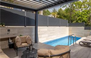 a patio with a pool and a table and chairs at Stunning Apartment In Crikvenica in Crikvenica +25 photos