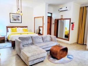 a living room with a bed and a couch at La Vista Residences and Safaris in Jinja