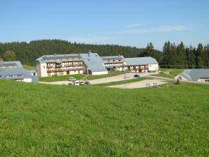 een groep gebouwen op een heuvel met een groen veld bij Village Vacances Passion Georges Moustaki in Les Moussières