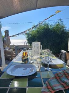 a table with plates and glasses on a table with the beach at CasaEole in El Haouaria
