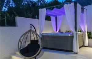 a swing in a backyard with purple lights at Awesome Home In Crikvenica With Sauna in Crikvenica +43 photos