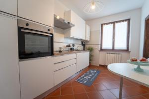 a kitchen with white cabinets and a flat screen tv at B&B Ulivo del Duca in Fermignano +13 photos