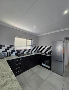 a kitchen with black and white tiles and a refrigerator at Klein Escape in Wilderness