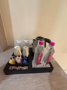 a coffee pot and two bottles of water on a tray at Sethi Grand Hotel in Lucknow