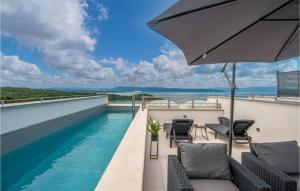 balcone con piscina e ombrellone di 3 Bedroom Beautiful Home In Njivice a Njivice