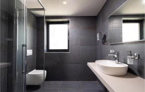 a bathroom with a sink and a glass shower at Lovely Apartment In Malinska in Malinska