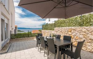 a table with chairs and an umbrella on a patio at Beautiful Home In Njivice With Wifi in Njivice