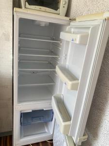 an empty refrigerator with its door open in a room at Ventspils Juras in Ventspils