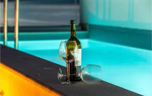 a bottle of wine and a glass on a table at Beautiful Home In Njivice With Wifi in Njivice