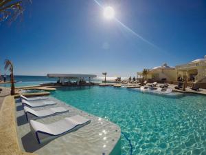 einen Pool mit weißen Liegestühlen und Meerblick in der Unterkunft Las Palmas Resort Rocky Point Mexico in Campo del Medio