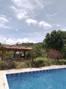 a swimming pool with a gazebo in a yard at Finca las Margaritas in Estación El Salto