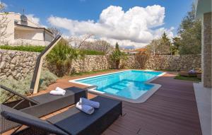 a swimming pool with two lounge chairs next to a house at Lovely Home In Kolanjski Gajac With Wifi in Skunca +35 photos