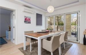 a white dining room with a wooden table and chairs at Lovely Home In Kolanjski Gajac With Wifi in Skunca