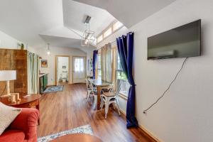 a living room with a table and a tv on a wall at 5 Mi to Lake Ouachita Peaceful Cabin Retreat in Royal