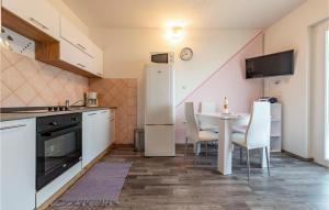 a kitchen with a table and a white refrigerator at 1 Bedroom Cozy Apartment In Povljana in Povljana