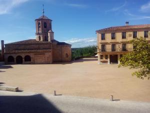 a large courtyard with a building and a church at Hostal Plaza Mayor de Almazán in Almazán