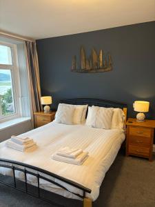 a bedroom with a bed with two towels on it at Bryn Melyn Apartments in Barmouth