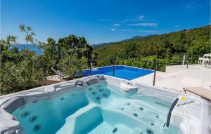 a hot tub on a patio with a mountain at Pet Friendly Home In Matulji With Sauna in Opatija